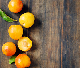 Wall Mural - Yellow plums on wooden background with copy space. Stone fruits