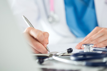 Close up view of female medicine doctors hands filling patient m