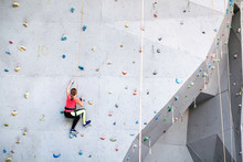Active Young Woman On Rock Wall In Sport Center