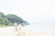 © peach100 - ビーチを歩く新郎新婦