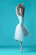 © master1305 - Ballerina in white dress posing on toes, studio background.