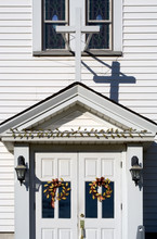 Front Door Of Church At Christmastime – The Front Doors Of A Church Are Decorated With Holiday Wreaths. Cross Above Doors.