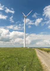 wind turbine produces energy on a background of clouds in the summer