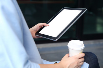 Woman holding mockup tablet and holding coffee cup with office b