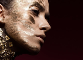 beautyful girl with gold glitter on her face. art image beauty