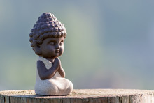 Silhouette Of Little Buddha Or Baby Practicing Yoga, Meditate And Pray On Wooden Surface