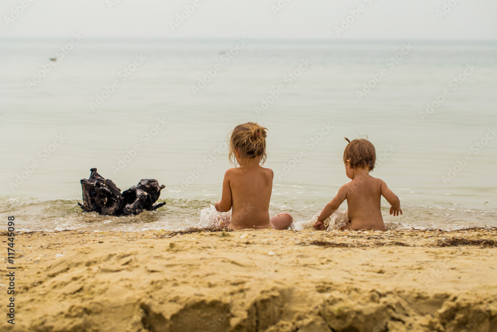 little kids nudist two little girls in the Nude playing in the sea の Stock フォト | Adobe Stock