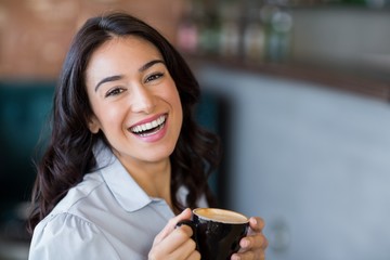 Portrait of smiling woman having cup of coffee