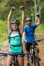 Athletic Couple Standing With Mountain Bike In Forest