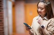 © WavebreakmediaMicro - Young woman using mobile phone in corridor