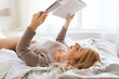 © Syda Productions - young woman reading book in bed at home