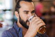 © Syda Productions - happy man drinking beer at bar or pub