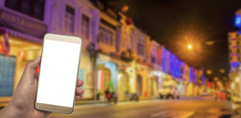 Hand with smart phone on blurred night city