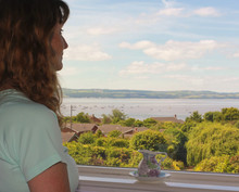 A Woman Admires An Ocean View Through A Window