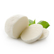 Piece of white mozzarella isolated on white background with clipping path. Decorated with basil. Front view.