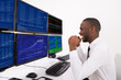 © Andrey Popov - Happy Stock Market Broker Looking At Graphs On Multiple Computer