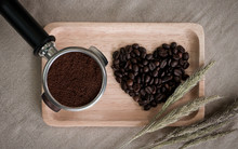 Heart From Coffee Beans And Wooden Spoons With Coffee Maker Prepared On The Desktop