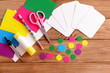 Cut cards and circle, scissors, pencil, glue, colored paper sheets on a wooden table. How to make educational flashcards from cardboard for teaching children. Top view. Tutorial. Step