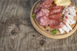 Tagliere di prodotti tradizionali italiani con salami, affettati e formaggio su sfondo rustico