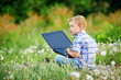 © fisher05 - young boy in field with dandelions with a laptop