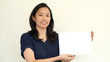 © glowonconcept - South East Asian girl casually holding while sign for copy space
