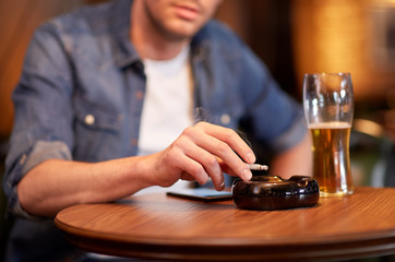 Wall Mural - man drinking beer and smoking cigarette at bar