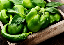 Green Bell Peppers In A Box On A Wooden Background