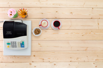 Two cups of black coffee alongside a till