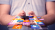 © ra2 studio - Man holding smart phone with colorful application icons
