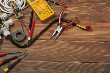 Wall Mural - Set of electrical tool on wooden background. Accessories for engineering work, energy concept.