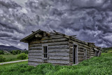 Fototapeta  - Old abandon log home outside of Yampa Colorado with a building storm in the sky.