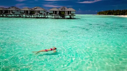 Wall Mural - young woman swimming in a coral lagoon, maldives.