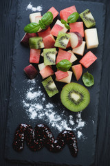 Poster - Above view of a stone slate tray with fruit salad, closeup