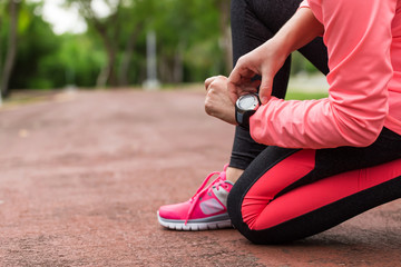 Wall Mural - sports athlete runner woman looking at heart rate monitor after