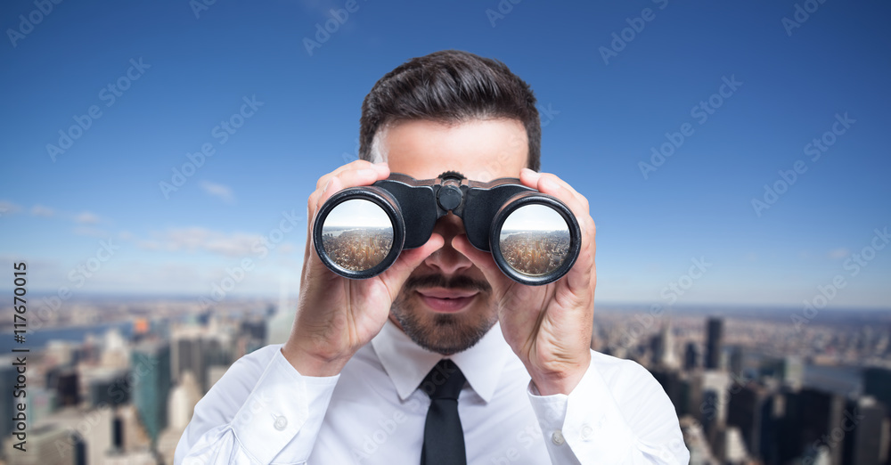 Businessman using binoculars to look at the city - obrazy, fototapety, plakaty 