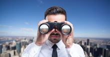 Businessman Using Binoculars To Look At The City
