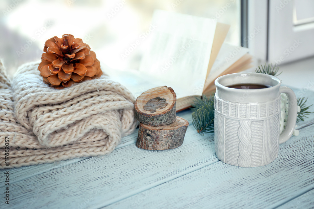 Beautiful winter composition on windowsill with cup of hot drink