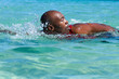 © mimagephotos - African male swimmer swimming in sea
