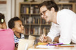 © Astrakan Images - Happy male teacher teaching students during art class