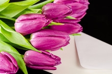 Bunch Of Purple Tulips With Letter On Dark Wooden Background