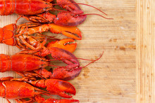 Border Of Four Red Lobsters On A Wooden Board