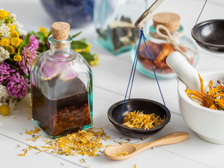 Bottles of tincture and healthy herbs, mortar on table. 