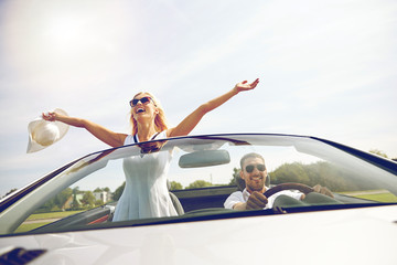 Wall Mural - happy man and woman driving in cabriolet car