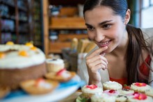 Happy Woman Looking At A Plate Of Cupcakes
