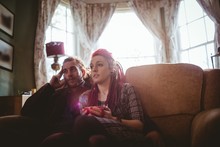 Couple Watching Television While Sitting On Sofa