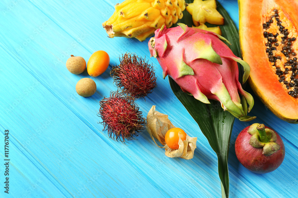 Juicy exotic fruits on blue wooden background