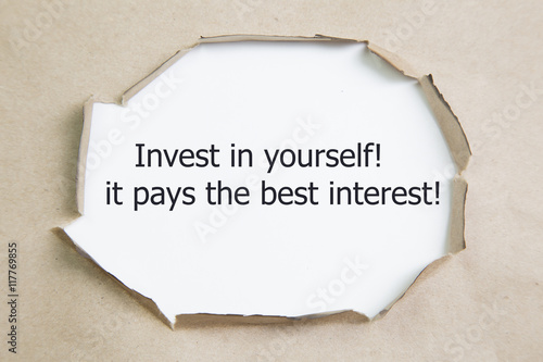 Fotografía The quote Invest in yourself, it pays the best interest, appearing behind ripped paper