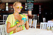 Woman with the drink on the beach in a bar on a tropical island