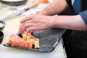 male cooks preparing sushi in the restaurant kitchen
