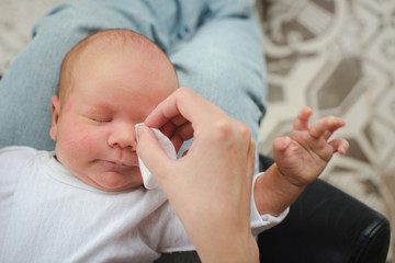 Mother cleaning eyes of a newborn baby